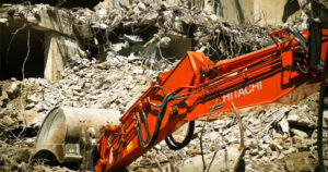 backhoe clearing up collapsed building debris