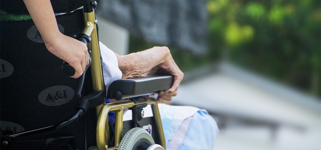 hospice nurse and elderly woman in wheelchair